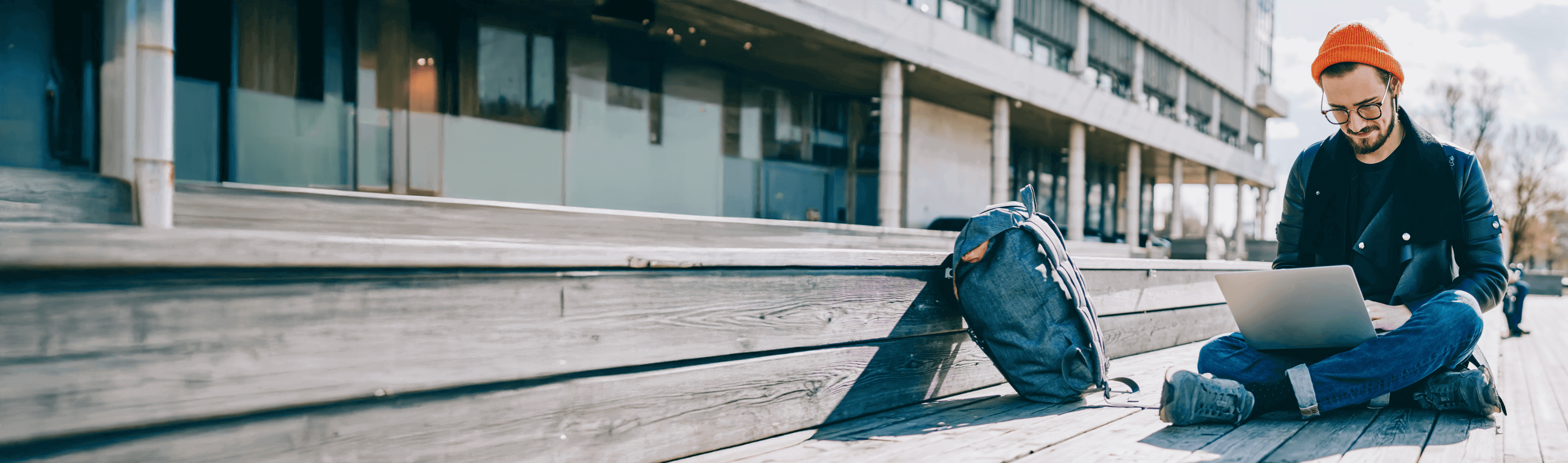 mann-sitzt-draussen-und-arbeitet-am-laptop